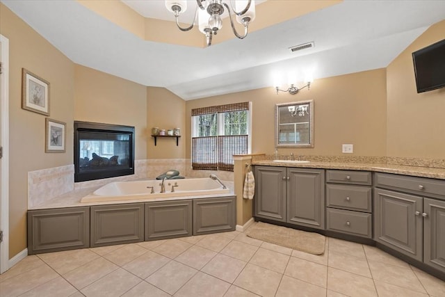 full bath featuring a garden tub, visible vents, tile patterned flooring, vanity, and an inviting chandelier
