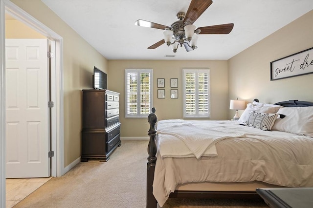 bedroom featuring baseboards, light carpet, a ceiling fan, and visible vents