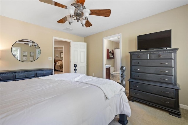bedroom with carpet floors, a ceiling fan, visible vents, and connected bathroom