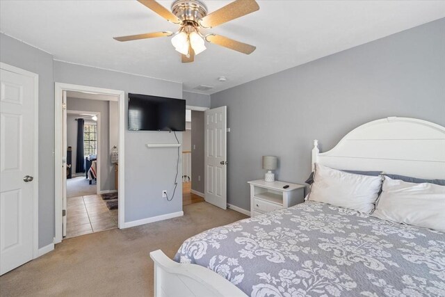 bedroom featuring baseboards, ceiling fan, and light colored carpet