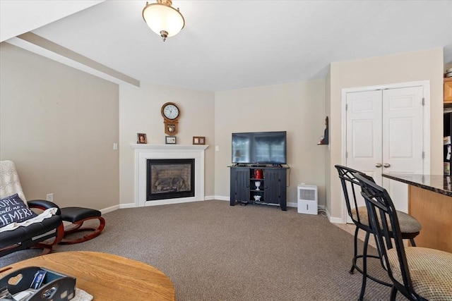 living room featuring baseboards, carpet, and a fireplace