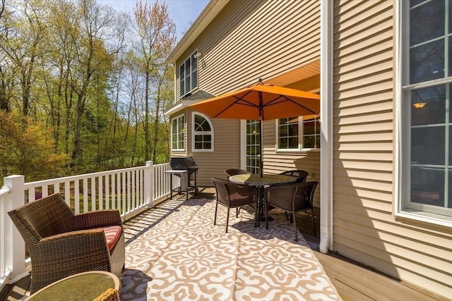 wooden deck with grilling area and outdoor dining area