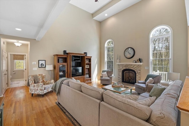 living room with recessed lighting, light wood finished floors, a brick fireplace, and baseboards