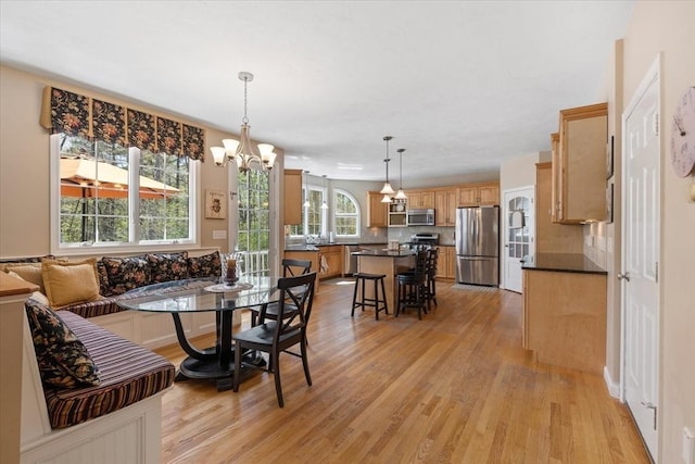dining area with light wood-type flooring and a chandelier
