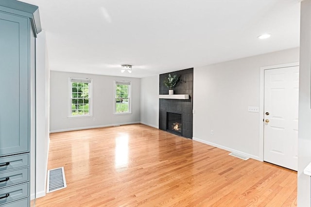 15 Pilgrim Rd, Mansfield, MA 02048 - unfurnished living room featuring light wood-style floors, a tiled fireplace, baseboards, and recessed lighting