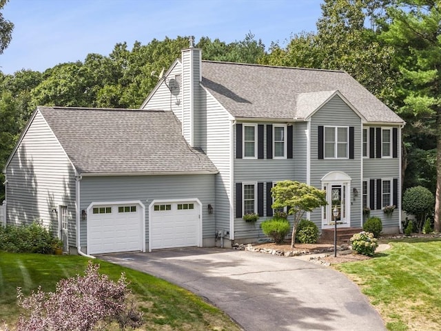 15 Pilgrim Rd, Mansfield, MA 02048 - colonial-style house with a garage, asphalt driveway, a chimney, a front lawn, and roof with shingles