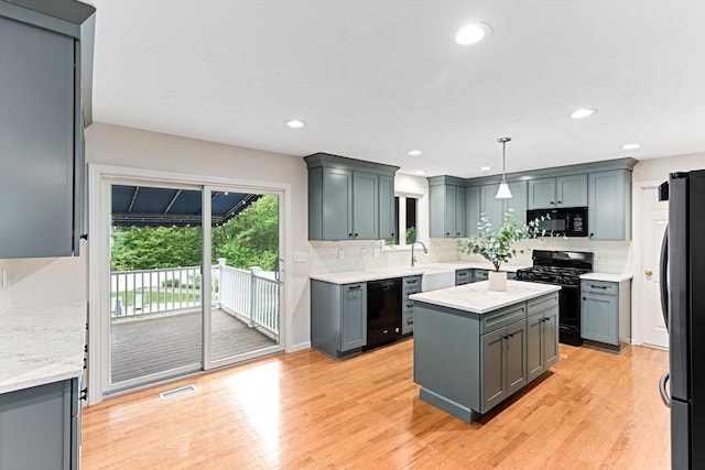 15 Pilgrim Rd, Mansfield, MA 02048 - kitchen featuring black appliances, backsplash, a kitchen island, light wood-style flooring, and recessed lighting