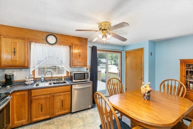 24 Alenclair, Amesbury, MA 01913 - kitchen featuring stainless steel appliances, brown cabinets, ceiling fan, dark countertops, and light tile patterned flooring