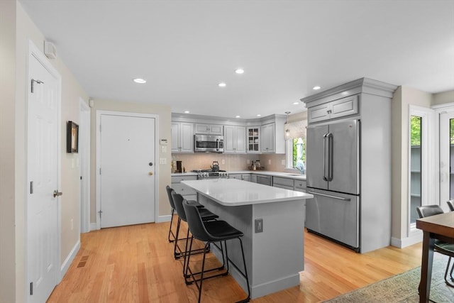 94 Mill Pond Unit 94, North Andover, MA 01845 - kitchen featuring stainless steel appliances, gray cabinetry, a breakfast bar area, light countertops, and a sink