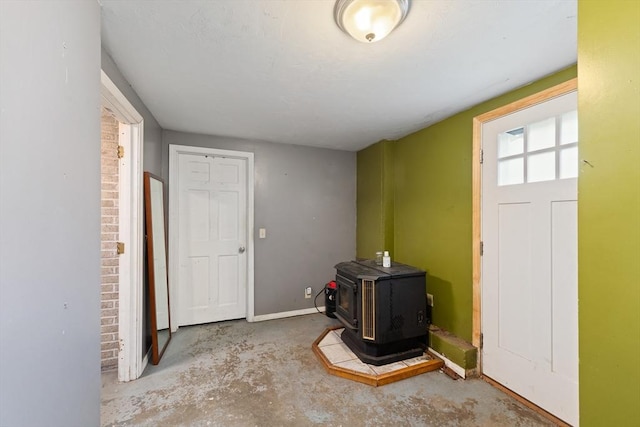140 W Mountain St, Worcester, MA 01606 - foyer featuring concrete flooring, a wood stove, and baseboards