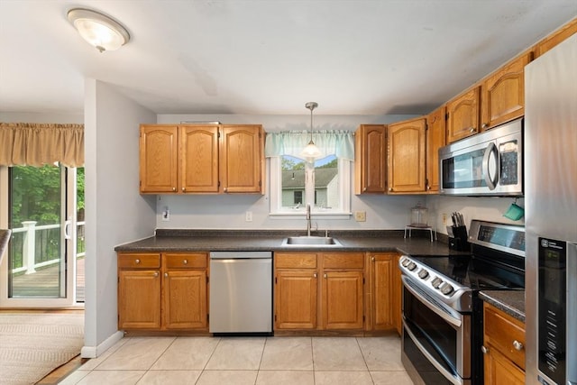140 W Mountain St, Worcester, MA 01606 - kitchen featuring appliances with stainless steel finishes, a sink, dark countertops, light tile patterned floors, and brown cabinets