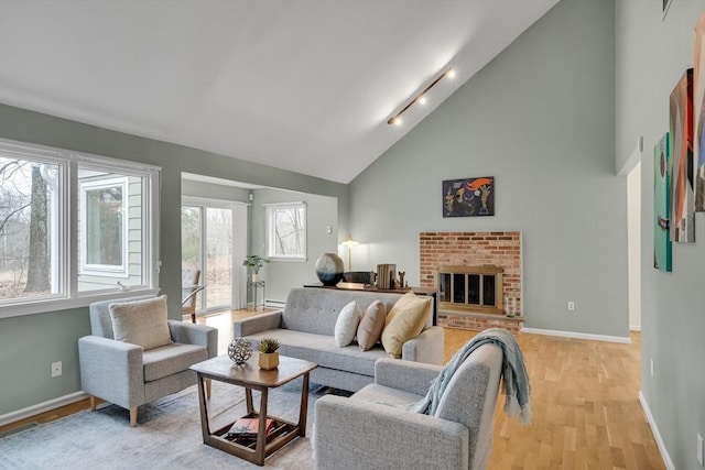 living room with light wood-type flooring, high vaulted ceiling, and a fireplace