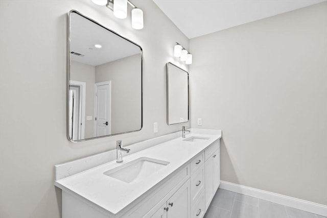 bathroom with visible vents, a sink, baseboards, and double vanity