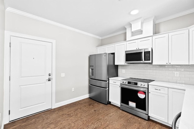 kitchen featuring ornamental molding, appliances with stainless steel finishes, dark wood-type flooring, light countertops, and backsplash