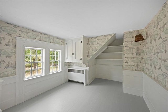 36 Uncle Barneys Rd, Dennis, MA 02670 - unfurnished bedroom with wallpapered walls, radiator heating unit, a wainscoted wall, and light wood-type flooring