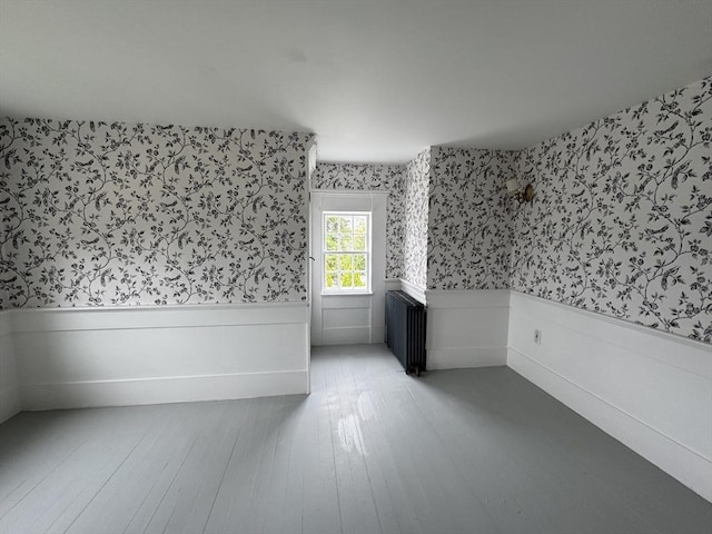 36 Uncle Barneys Rd, Dennis, MA 02670 - unfurnished room with wallpapered walls, wainscoting, wood finished floors, and radiator heating unit