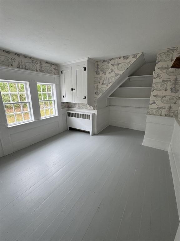 36 Uncle Barneys Rd, Dennis, MA 02670 - unfurnished living room featuring radiator, light wood-type flooring, wallpapered walls, and stairway