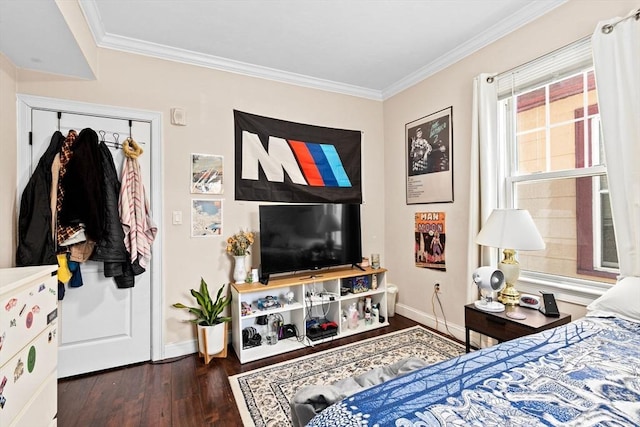 bedroom featuring baseboards, crown molding, and wood finished floors