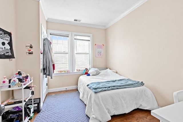 bedroom with crown molding, wood finished floors, baseboards, and visible vents