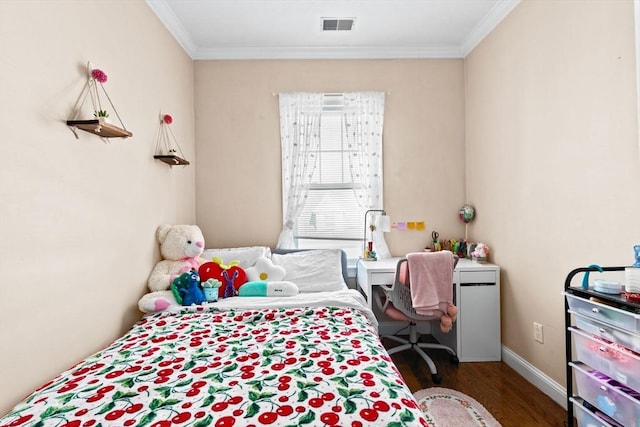 bedroom with wood finished floors, baseboards, ornamental molding, and visible vents