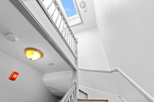 interior details featuring a fire alarm and wainscoting