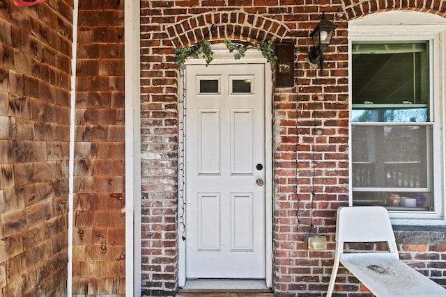 property entrance featuring brick siding