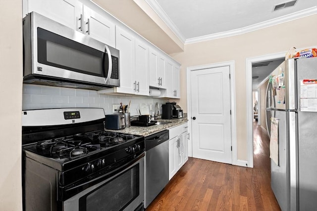 kitchen featuring crown molding, white cabinets, visible vents, stainless steel appliances, and a sink