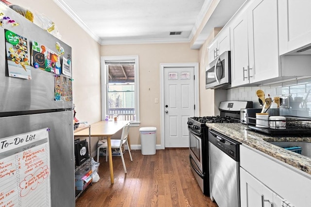 kitchen with dark wood-style floors, crown molding, white cabinetry, light stone countertops, and stainless steel appliances