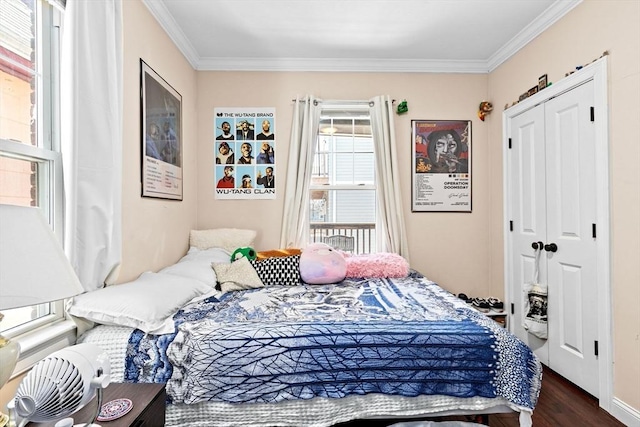 bedroom with dark wood finished floors, a closet, and ornamental molding