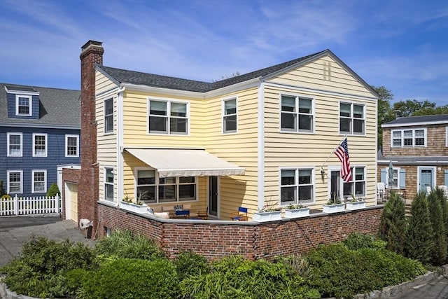 13 Selman St, Marblehead, MA 01945 - back of property with a chimney, driveway, and a garage