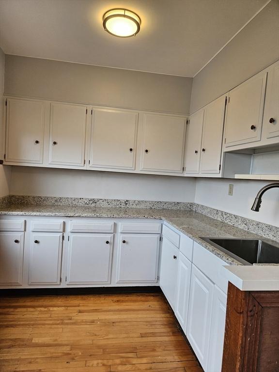 5 Watson Ave, Worcester, MA 01606 - kitchen featuring white cabinetry, light wood-style floors, and light stone countertops