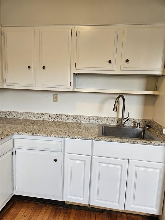 5 Watson Ave, Worcester, MA 01606 - kitchen with open shelves, white cabinetry, light stone counters, and dark wood-style floors