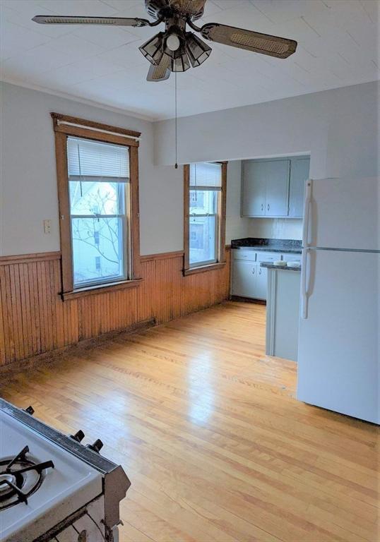 5 Watson Ave, Worcester, MA 01606 - unfurnished dining area featuring wainscoting, ceiling fan, light wood-style floors, and wooden walls