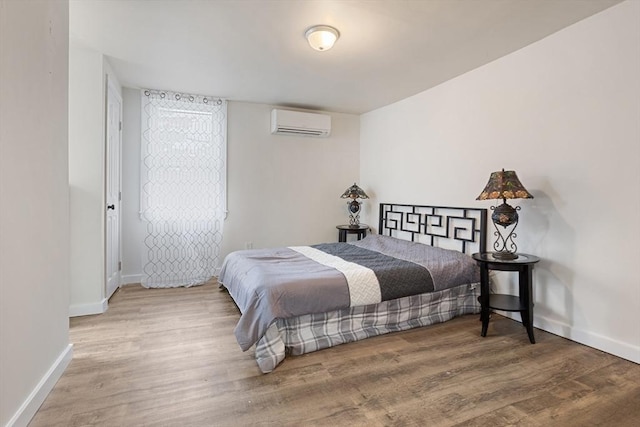 12 Temple Ave, Hudson, MA 01749 - bedroom featuring a wall unit AC, baseboards, and wood finished floors