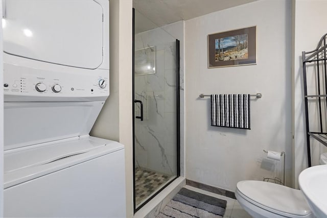 12 Temple Ave, Hudson, MA 01749 - full bathroom featuring stacked washer / drying machine, a marble finish shower, baseboards, and toilet