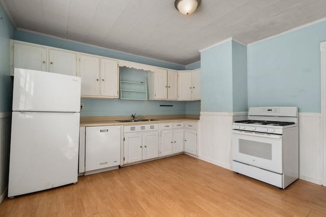 kitchen with white appliances, wainscoting, light wood-style flooring, light countertops, and white cabinetry