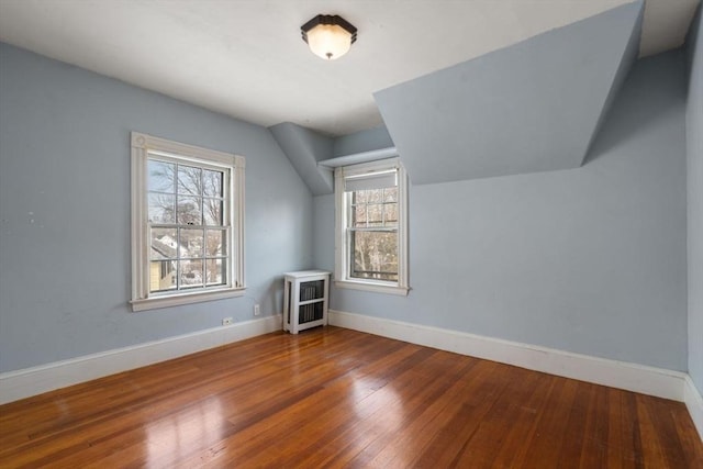 bonus room featuring vaulted ceiling, baseboards, and hardwood / wood-style flooring