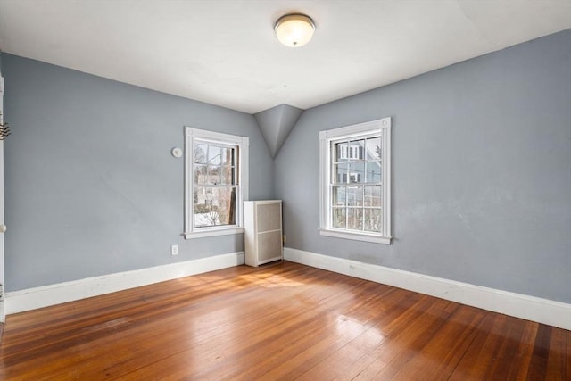 spare room featuring hardwood / wood-style flooring and baseboards