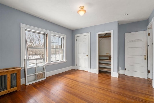 unfurnished bedroom featuring baseboards and hardwood / wood-style floors