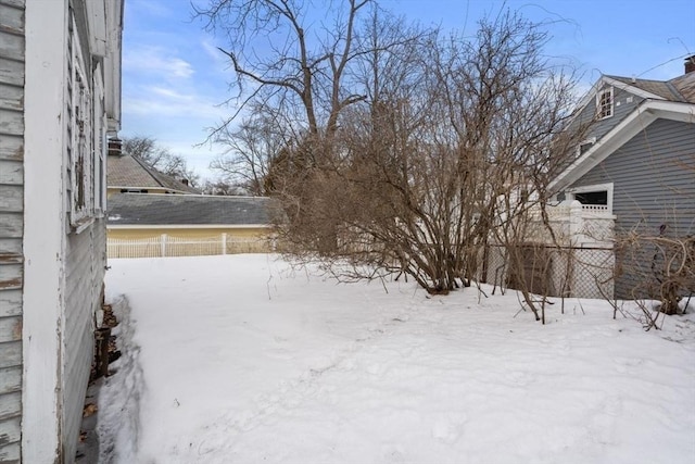 yard layered in snow with fence