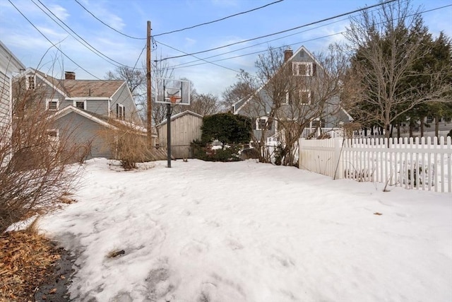 snowy yard with fence