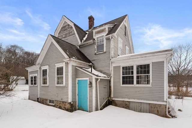 view of front of home featuring a chimney and roof with shingles