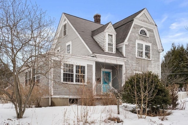 shingle-style home featuring roof with shingles and a chimney