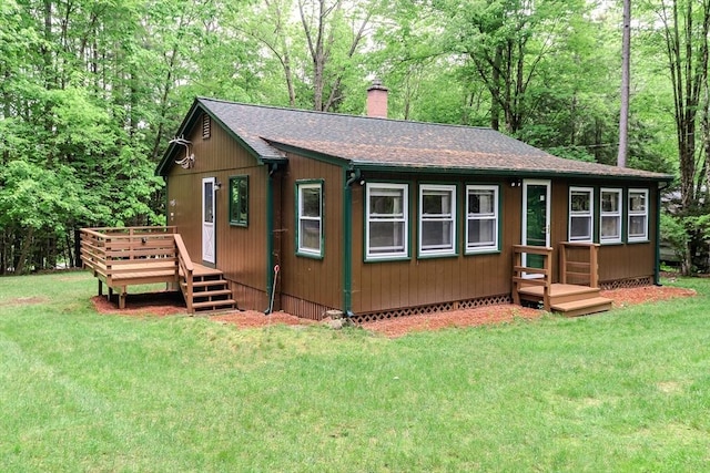 32 Birch Rd, Goshen, MA 01032 - view of front facade featuring roof with shingles, a chimney, a deck, and a front yard