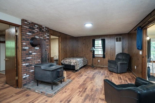 32 Birch Rd, Goshen, MA 01032 - living area featuring wood finished floors, wooden walls, healthy amount of natural light, and a wood stove