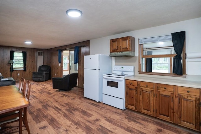 32 Birch Rd, Goshen, MA 01032 - kitchen with white appliances, under cabinet range hood, brown cabinets, dark wood-type flooring, and light countertops