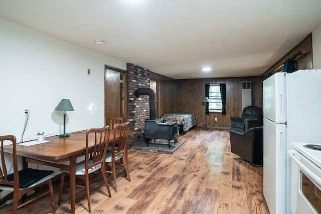 32 Birch Rd, Goshen, MA 01032 - dining space with a wood stove, light wood finished floors, and wood walls