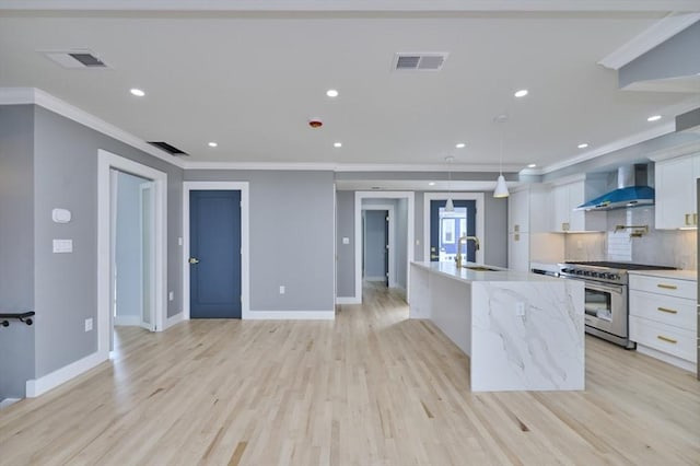 97 Oakton Ave, Boston, MA 02122 - kitchen with high end stove, wall chimney exhaust hood, white cabinetry, crown molding, and a spacious island