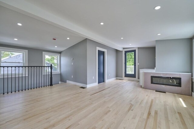 97 Oakton Ave, Boston, MA 02122 - unfurnished living room featuring light wood-type flooring, recessed lighting, a glass covered fireplace, and baseboards