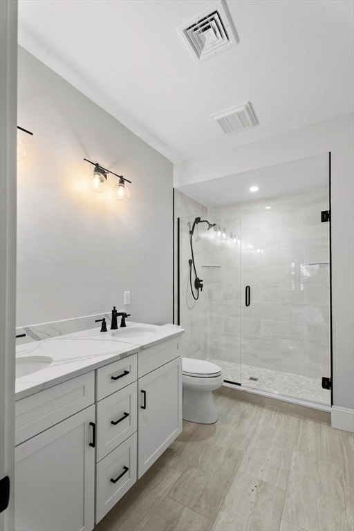 bathroom with vanity, toilet, and a shower with shower door